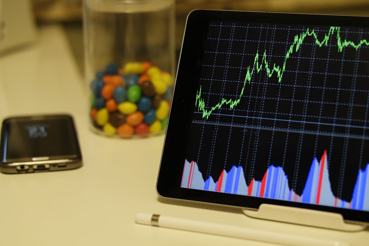 Services Tablet display of stock market data with smartphone and colorful candies on desk.